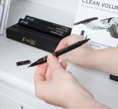 A photo of eyelash extension compatible makeup with retail display and marketing materials.